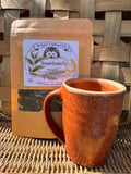 Skimrande Rosmarin Tea 2oz bag with a rustic ceramic mug on a wicker surface
